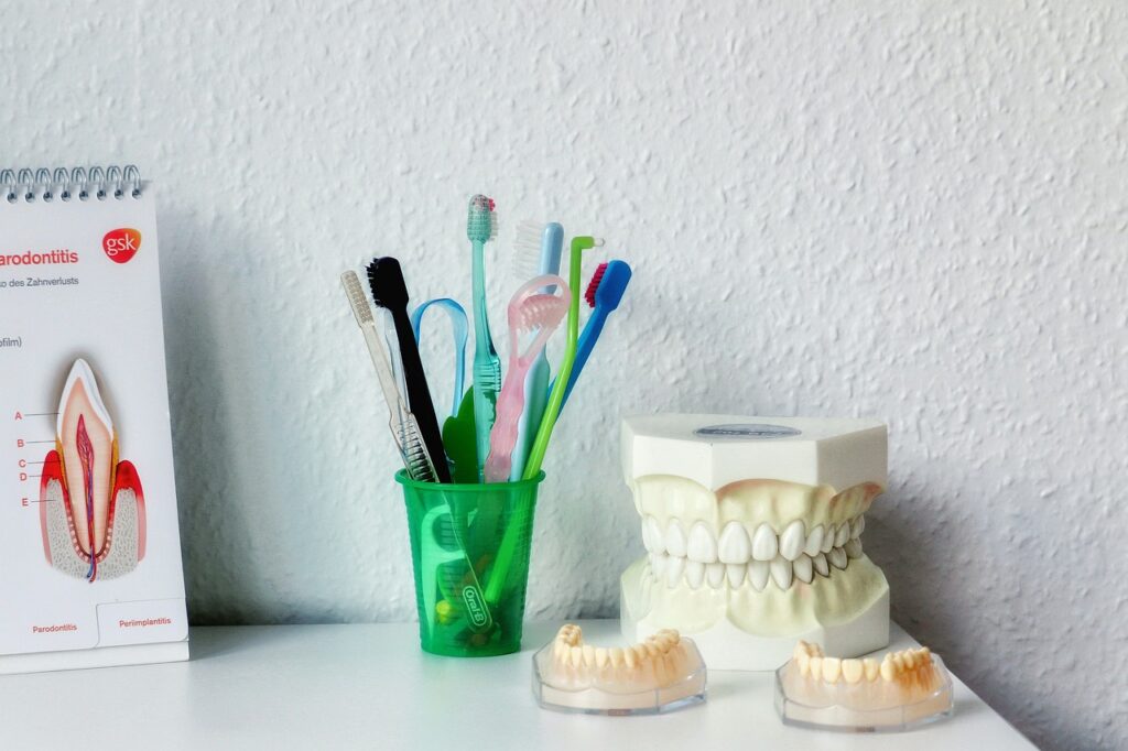 Brosses à dents, modèles dentaires et schéma de la parodontite sur un comptoir blanc