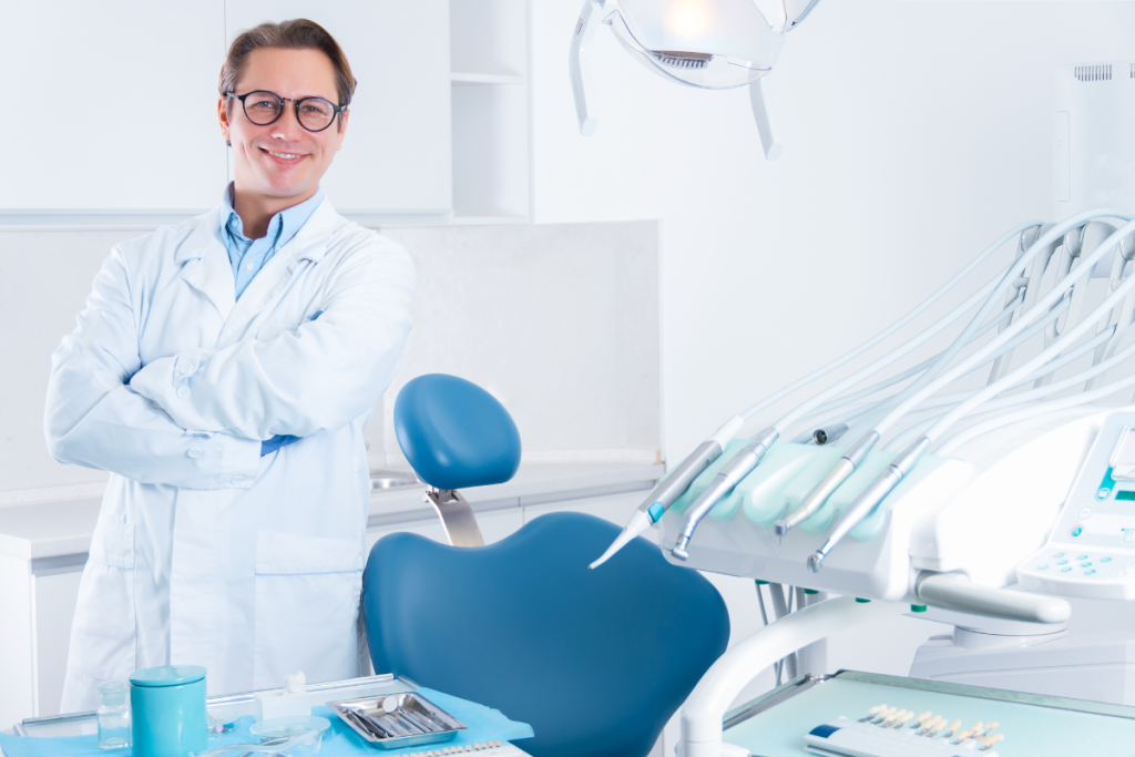 Un dentista sonriendo en la consulta. 
